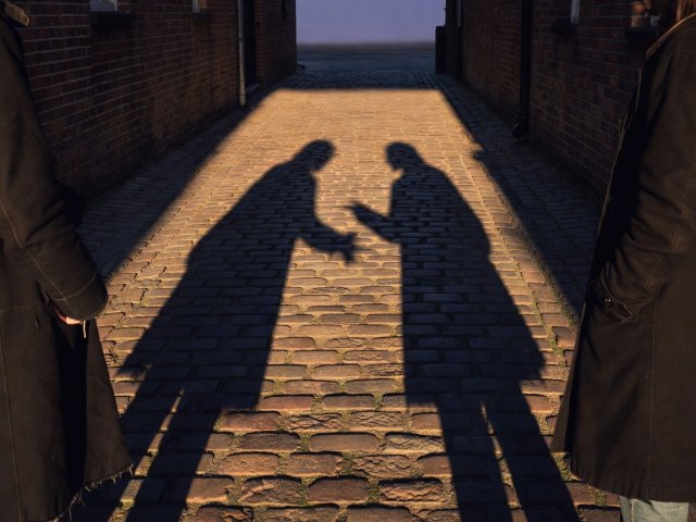 Two elongated evening shadows conversing on warm sunlit cobblestones while only the edges of coats appear in the frame